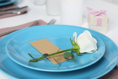 Elegant festive table setting with blank card on white wooden table