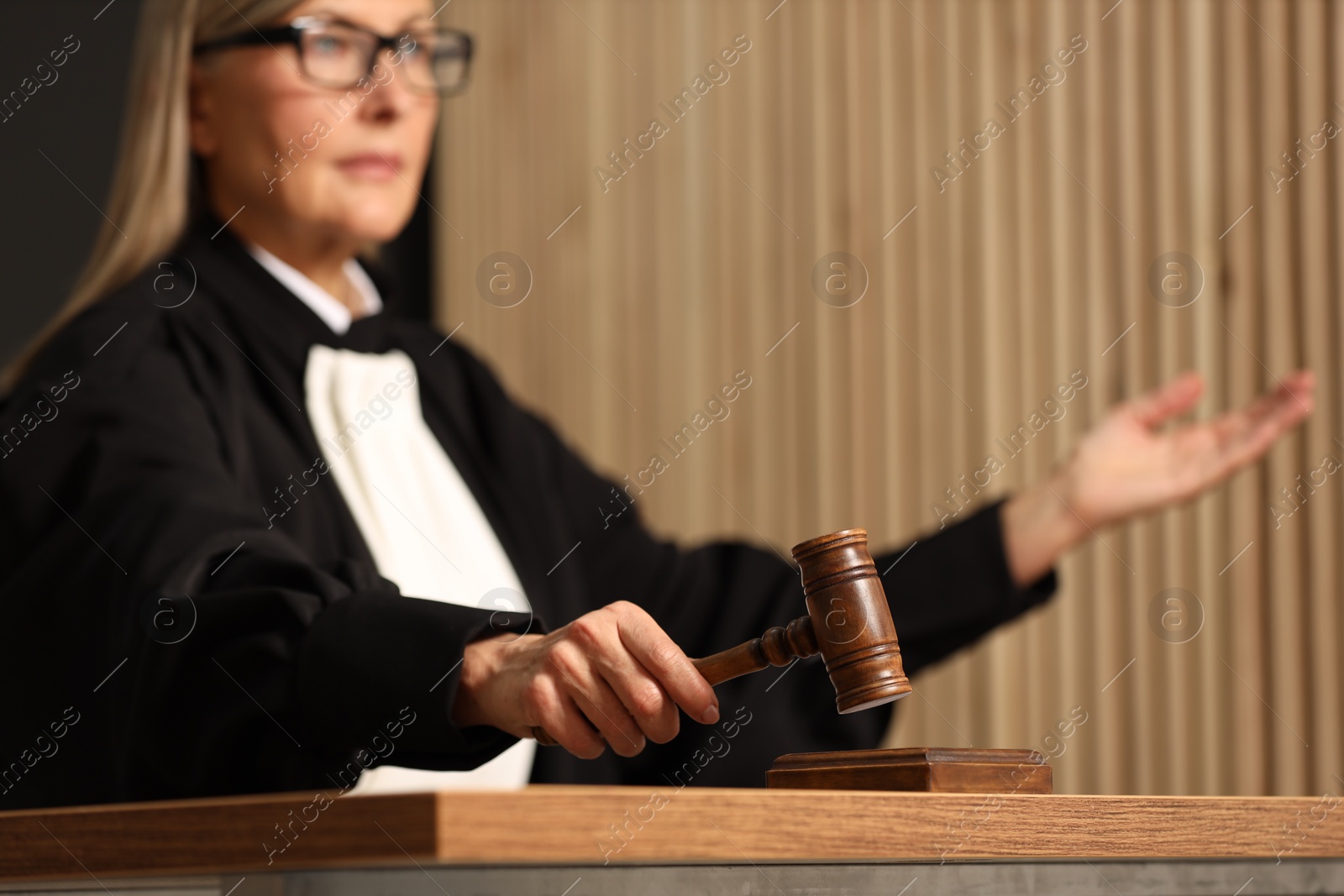 Photo of Judge striking mallet at wooden table indoors, selective focus. Space for text