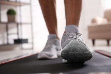 Man training on walking treadmill at home, closeup