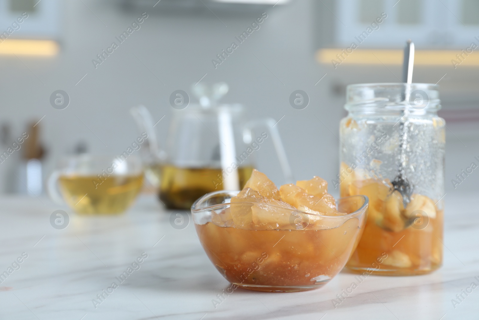 Photo of Delicious apple jam on white table. Space for text