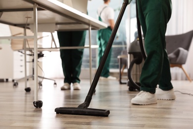 Photo of Professional janitor cleaning floor in modern office