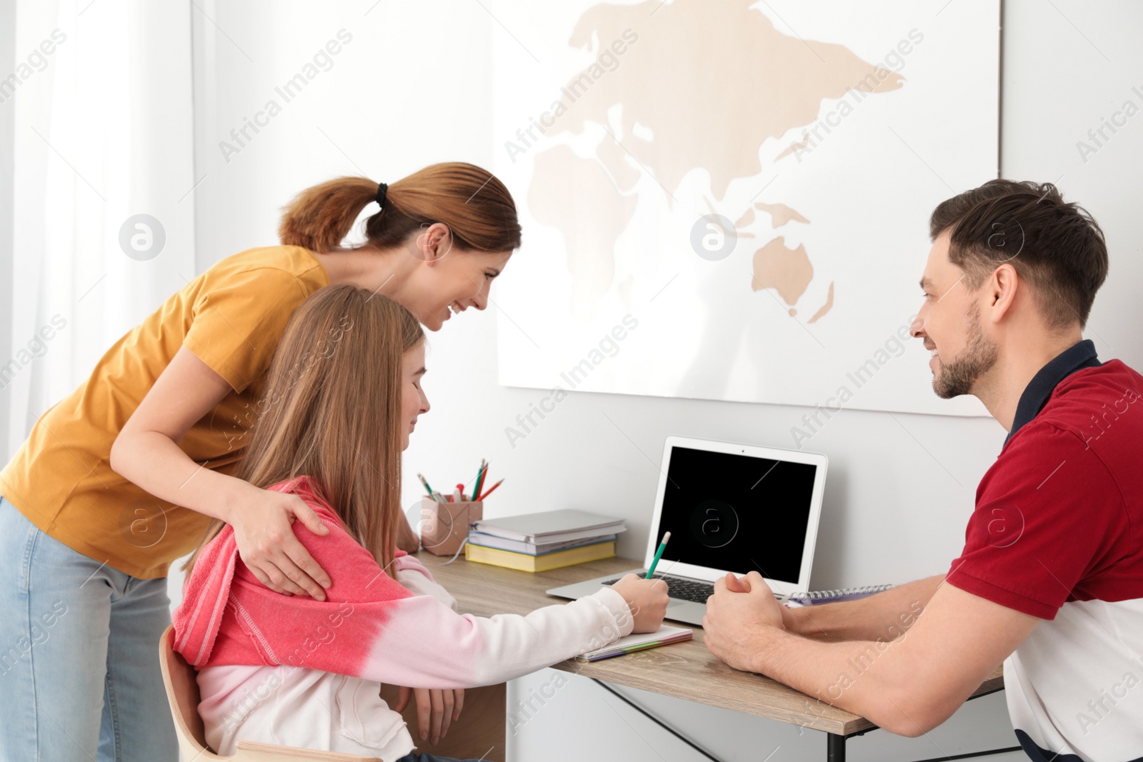 Photo of Parents helping their teenager daughter with homework indoors