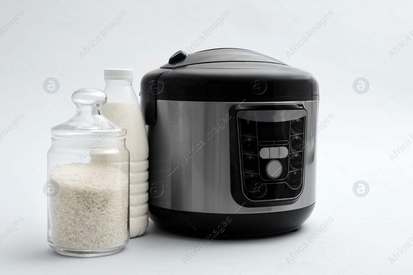 Photo of Modern electric multi cooker, rice and milk on light background