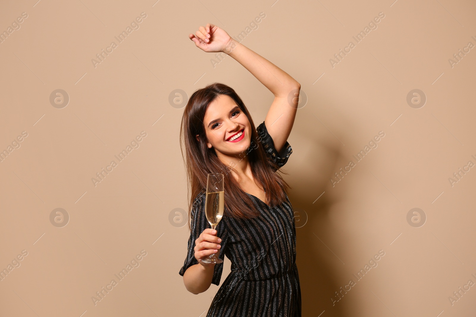 Photo of Portrait of happy woman with champagne in glass on color background