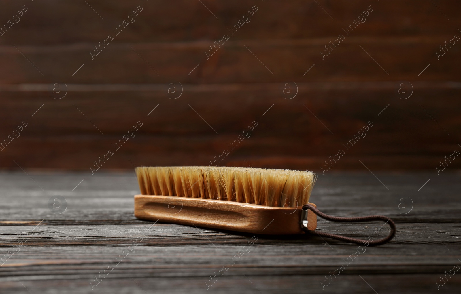 Photo of Shoe brush on wooden table. Footwear care item