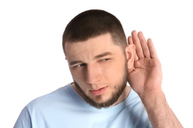 Young man with hearing problem on white background