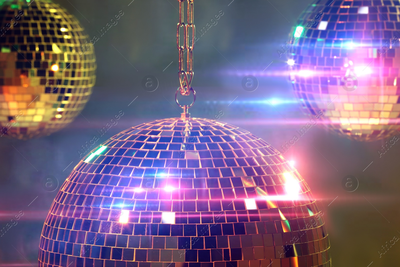 Photo of Shiny bright disco balls on under color lights