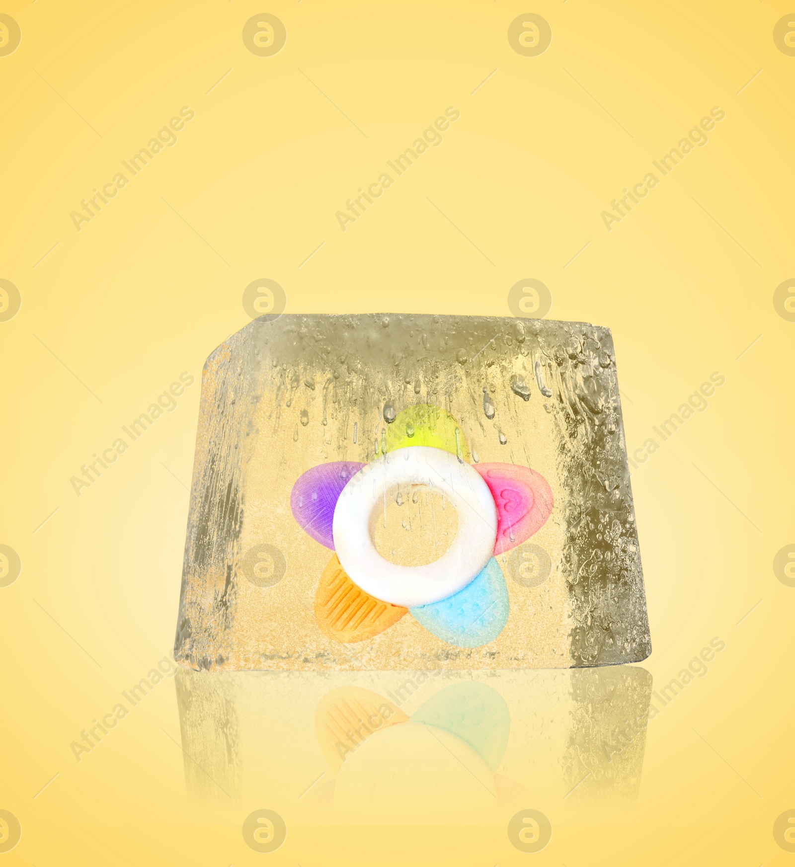 Image of Conservation of genetic material. Baby teether in ice cube as cryopreservation on yellow background