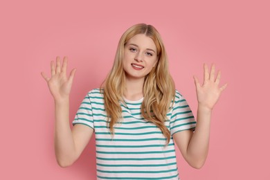 Happy woman giving high five with both hands on pink background