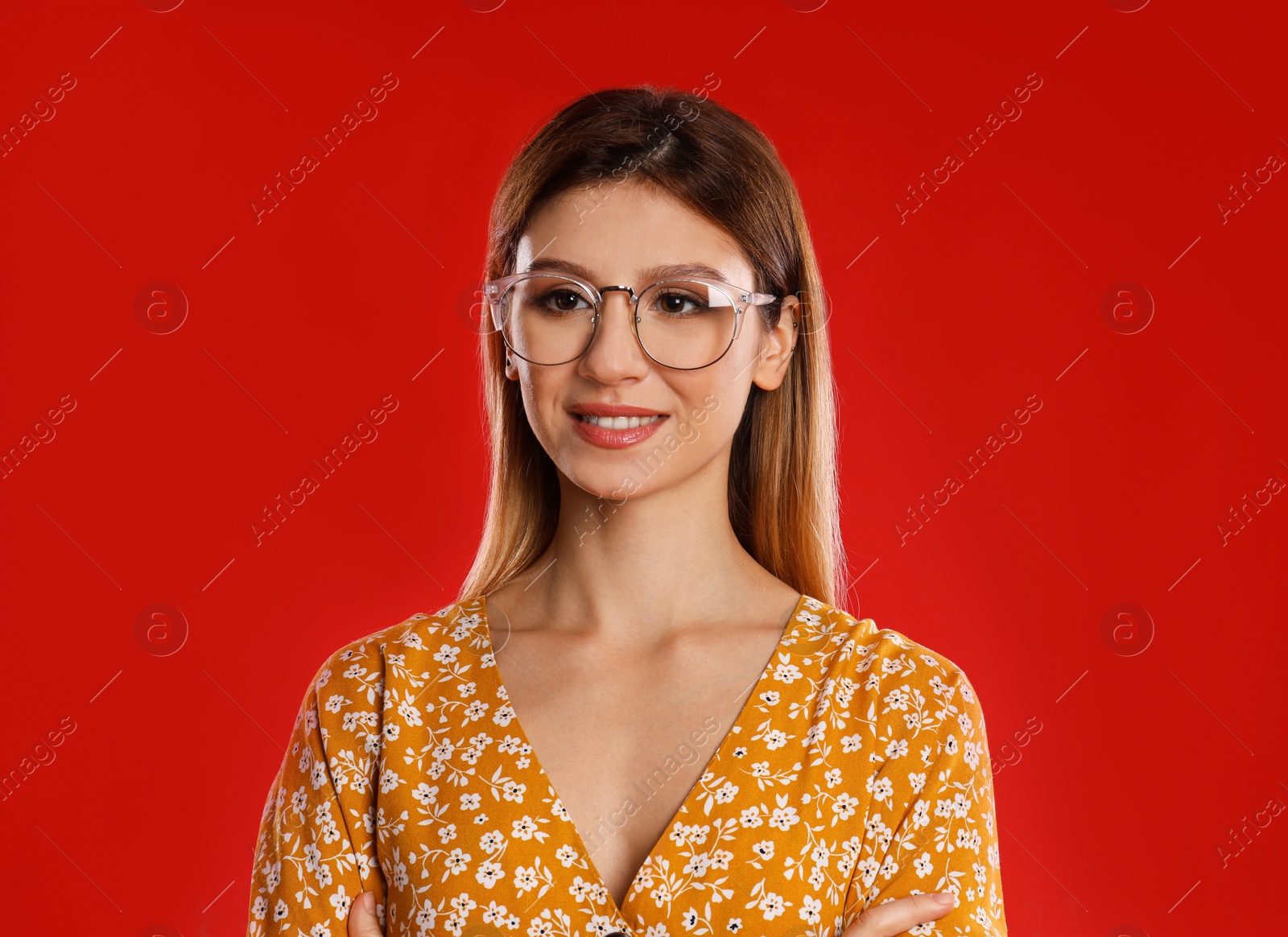 Photo of Portrait of young woman with glasses on red background