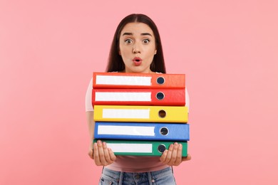 Photo of Surprised woman with folders on pink background