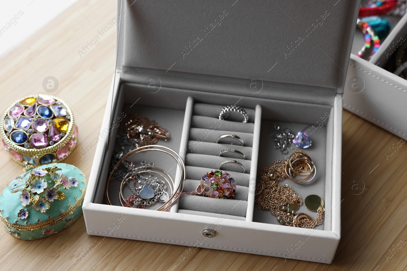 Photo of Jewelry boxes with many different accessories on wooden table