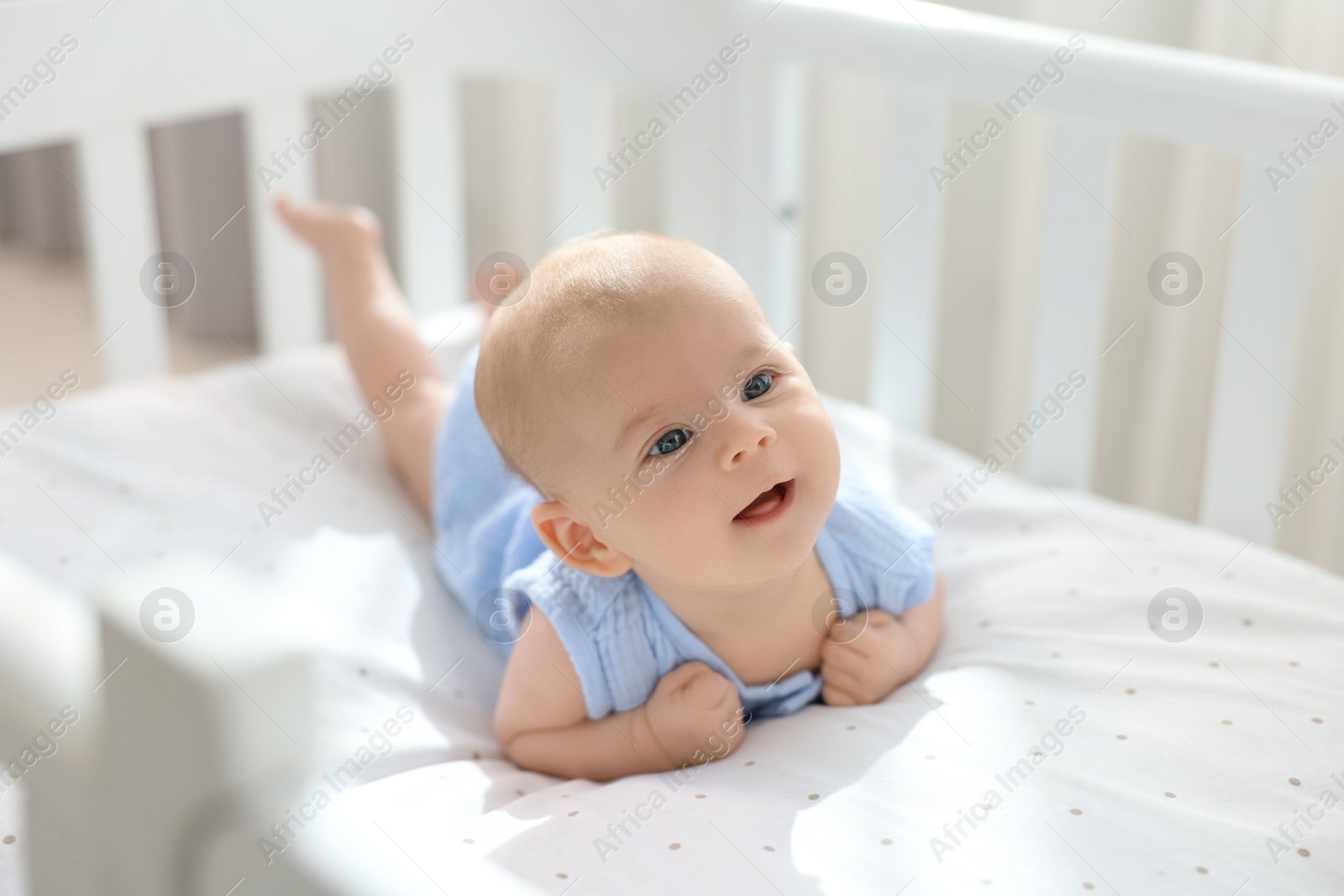 Photo of Cute little baby lying in crib at home