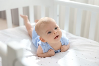 Photo of Cute little baby lying in crib at home