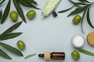 Photo of Cosmetic products with olive essential oil on light grey background, flat lay. Space for text