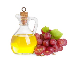 Photo of Organic red grapes, seeds and bottle of natural essential oil on white background