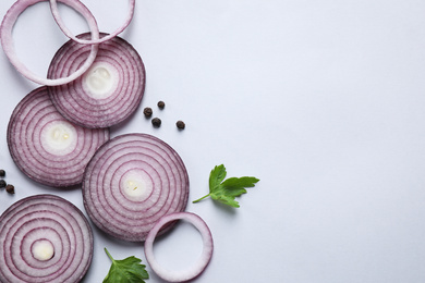 Photo of Flat lay composition with cut onion and spices on light background. Space for text