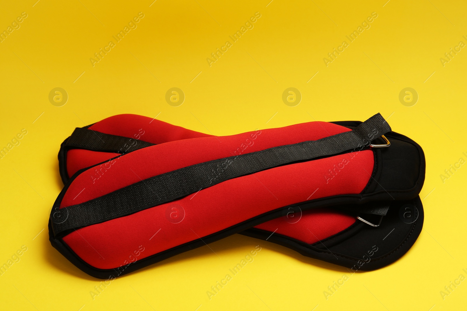 Photo of Stylish red weighting agents on yellow background