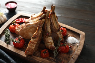 Photo of Delicious roasted ribs with served on wooden table, closeup