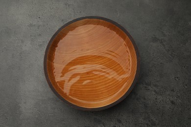 Photo of Wooden bowl with water on grey table, top view