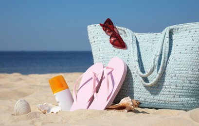 Photo of Bag and beach accessories on sand near sea