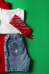 Stylish child clothes on green background, flat lay