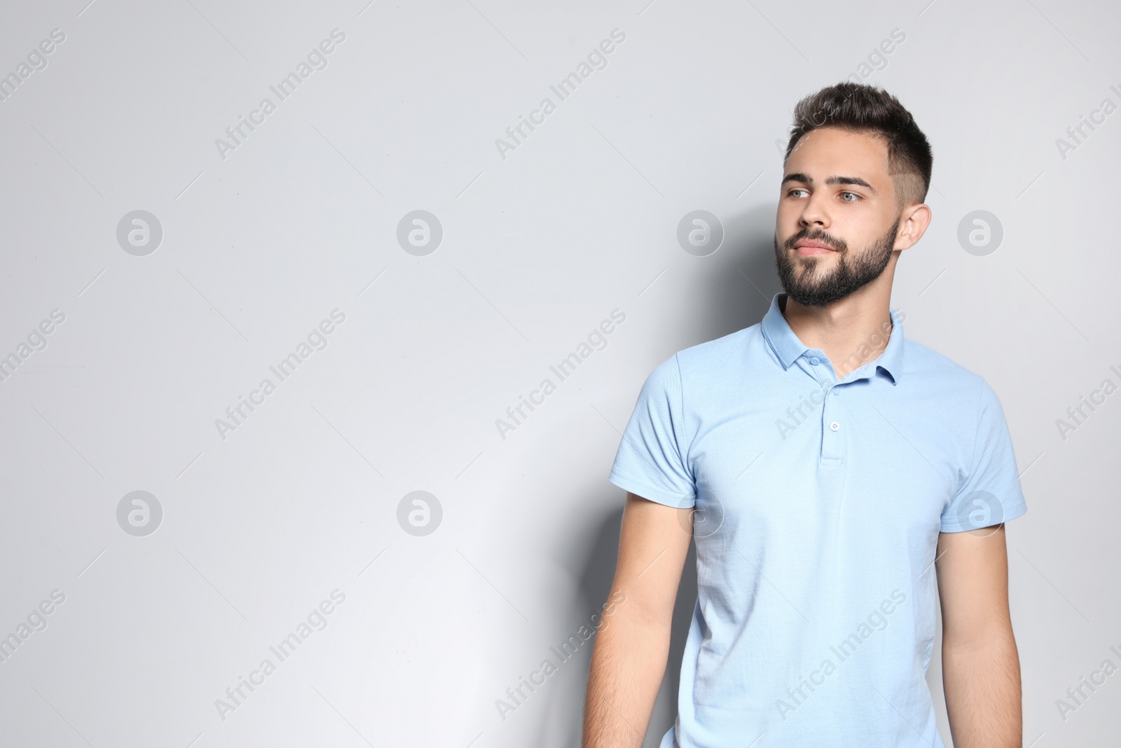 Photo of Portrait of handsome young man against light background. Space for text