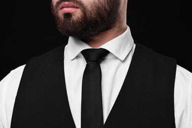Photo of Businessman in shirt and necktie on black background, closeup
