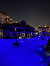 Beautiful view of swimming pool and buildings in city at night