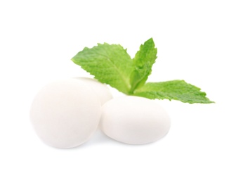 Tasty mint candies and leaves on white background