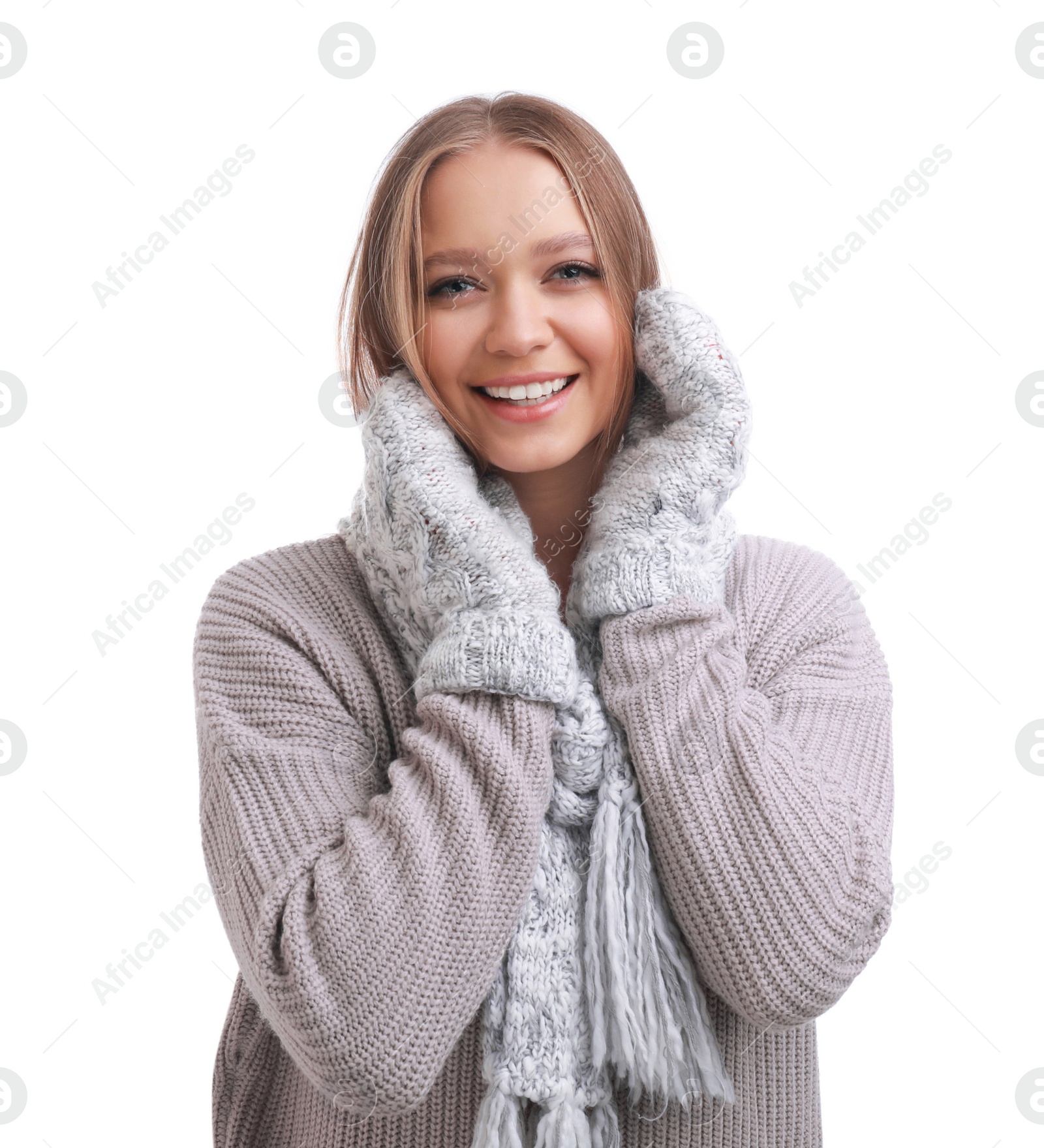 Photo of Young woman in warm sweater, mittens and scarf on white background. Winter season