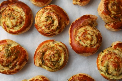 Photo of Fresh delicious puff pastry with tasty filling on parchment, flat lay