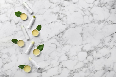 Photo of Flat lay composition with hygienic lipsticks and balms on light background