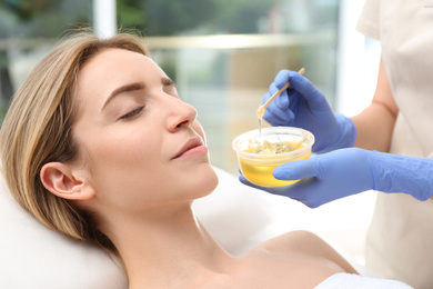 Photo of Beautiful woman getting wax epilation in salon