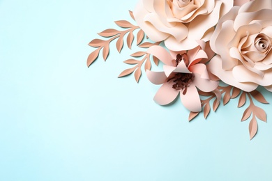 Photo of Different beautiful beige flowers and branches made of paper on light blue background, flat lay. Space for text