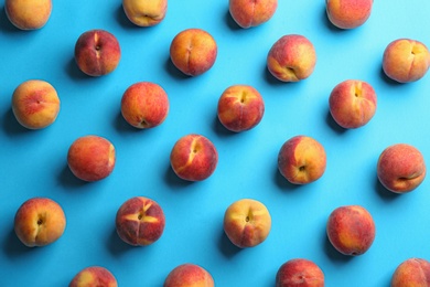 Photo of Fresh ripe peaches on light blue background, flat lay