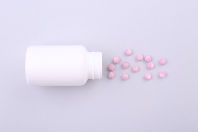 Photo of Jar with vitamin pills on white background, top view