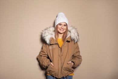 Photo of Young woman wearing warm clothes on color background. Ready for winter vacation