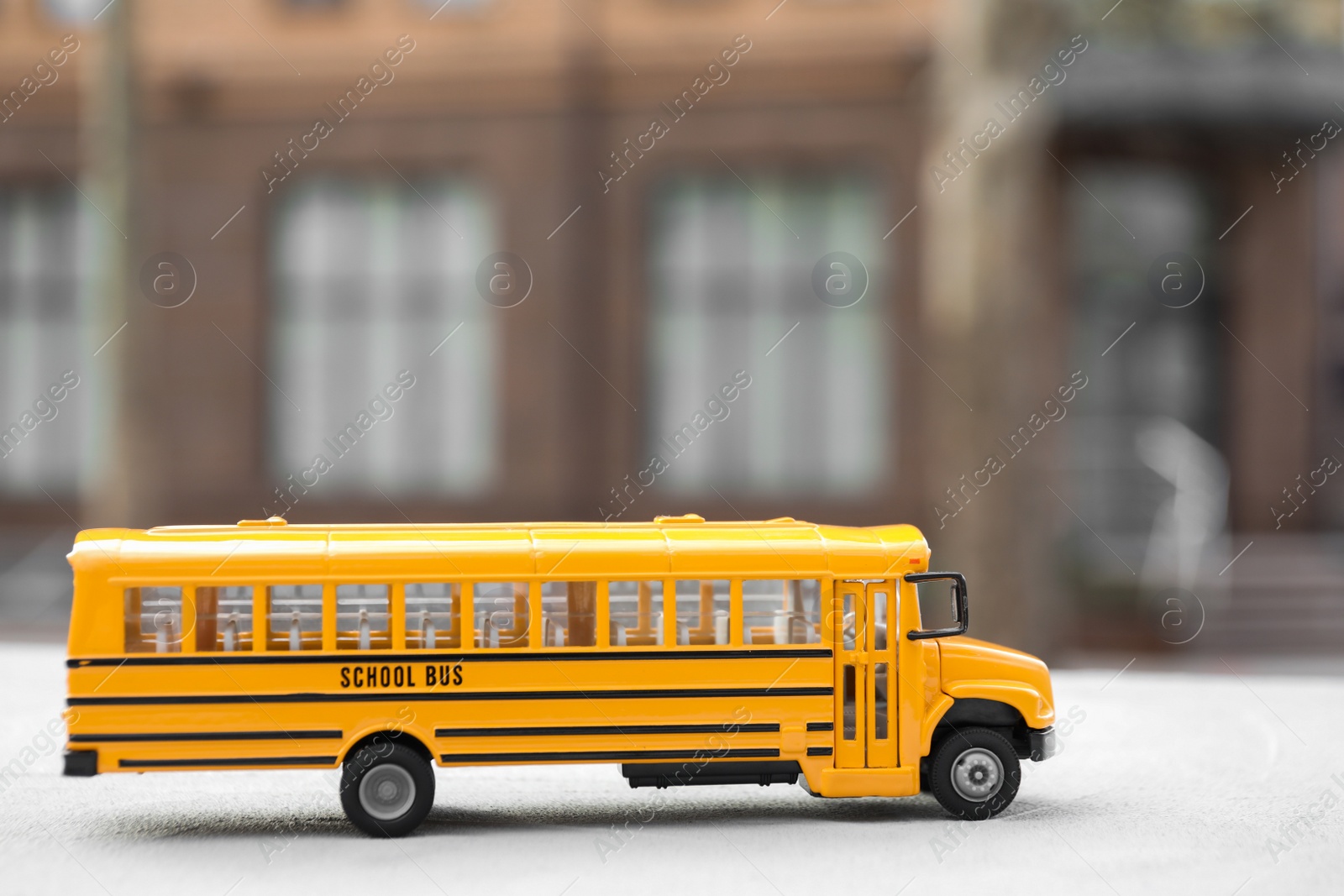 Photo of Yellow toy school bus outdoors, space for text. Transport for students