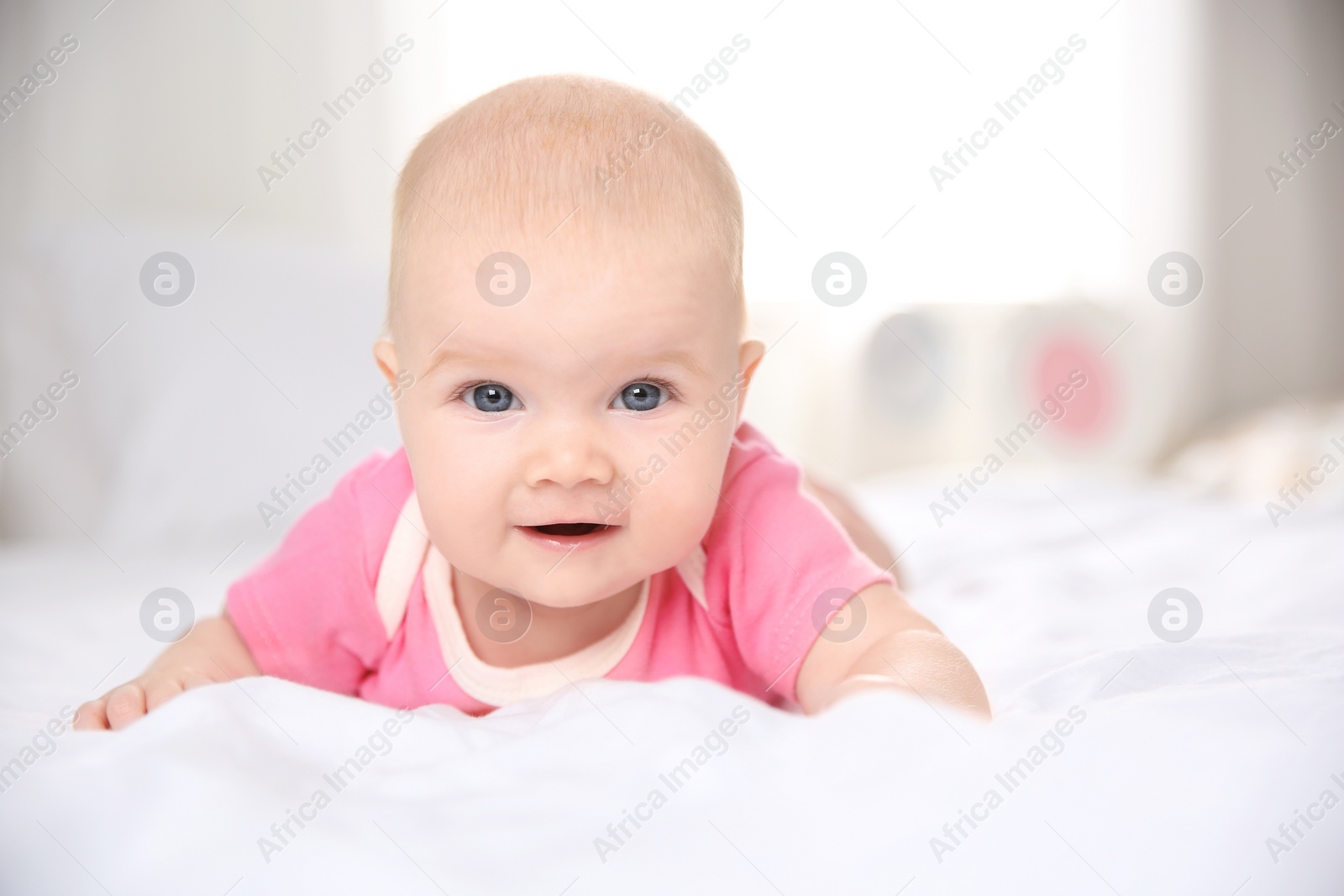 Photo of Pretty baby lying on bed at home, closeup