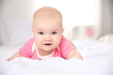 Pretty baby lying on bed at home, closeup