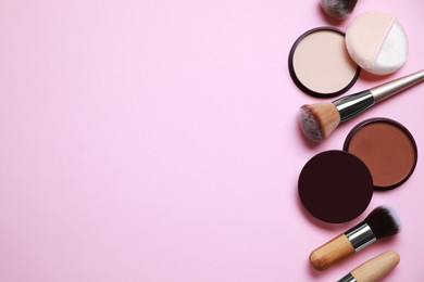 Photo of Different face powders and makeup brushes on pink background, flat lay. Space for text