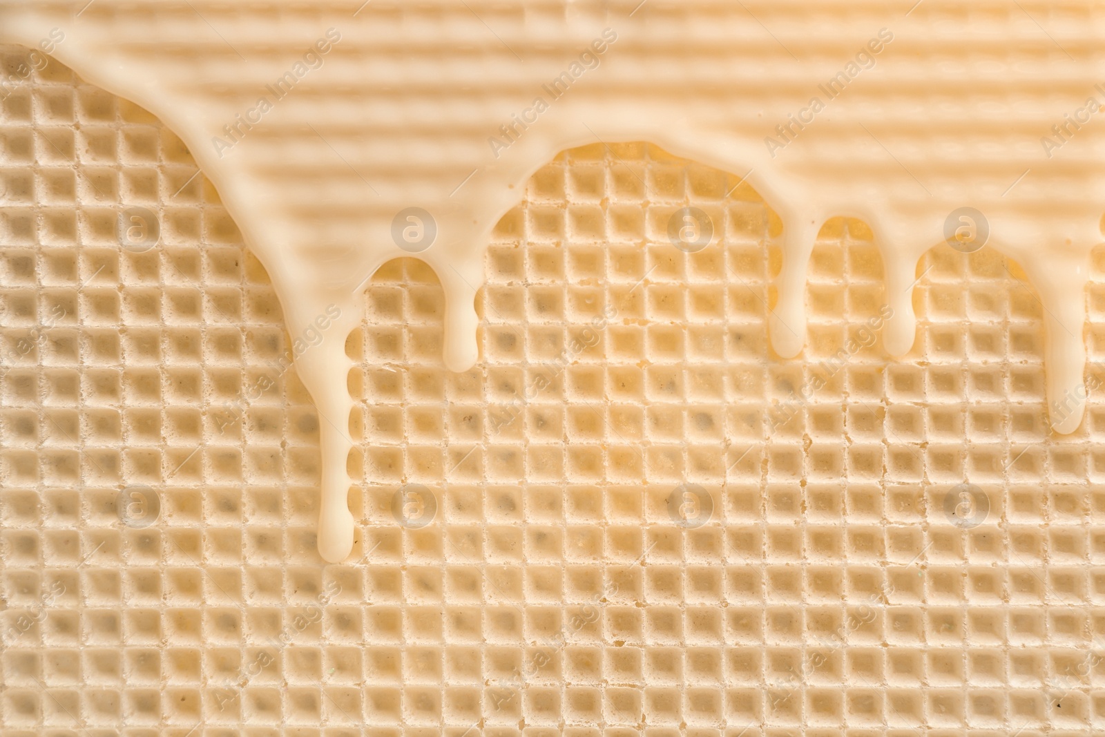 Photo of Hot white chocolate on wafer, closeup. Crispy food