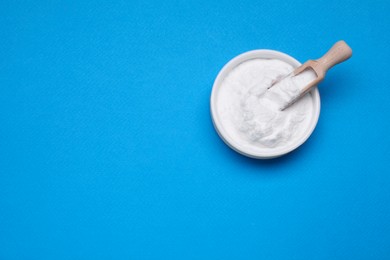Photo of Bowl of sweet powdered fructose on light blue background, top view. Space for text
