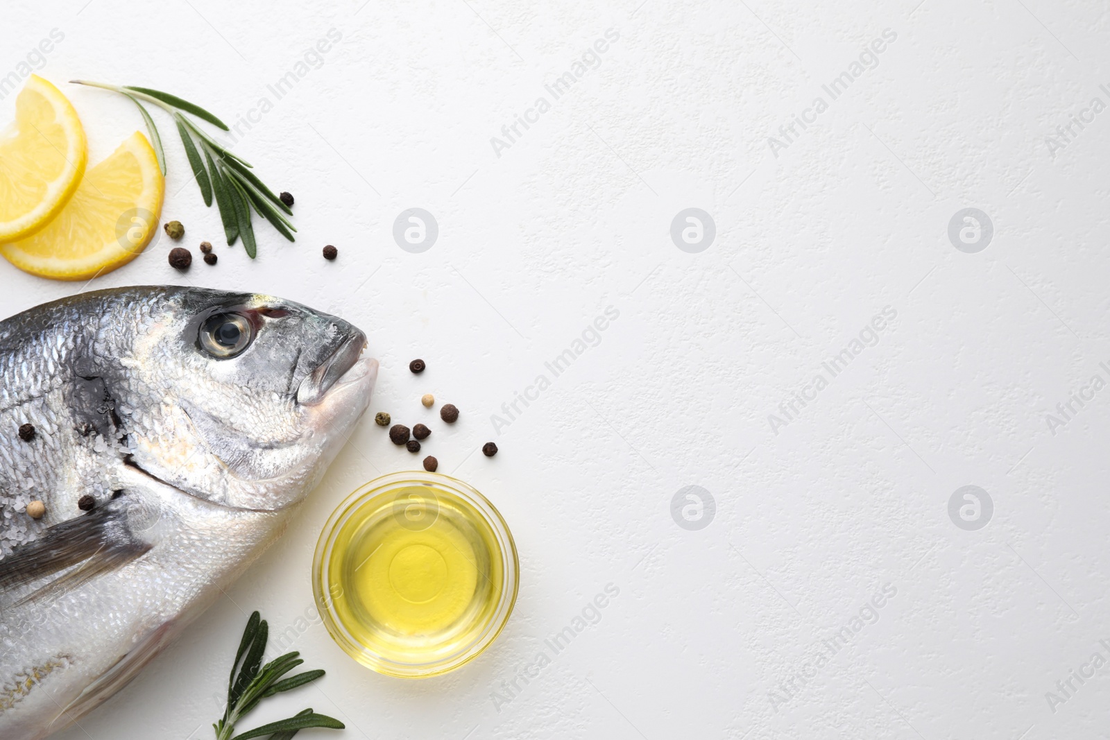 Photo of Flat lay composition with fresh raw dorado fish and ingredients on white table, space for text