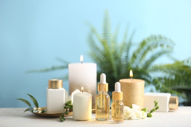 Beautiful spa composition with cosmetic products and candles on white table