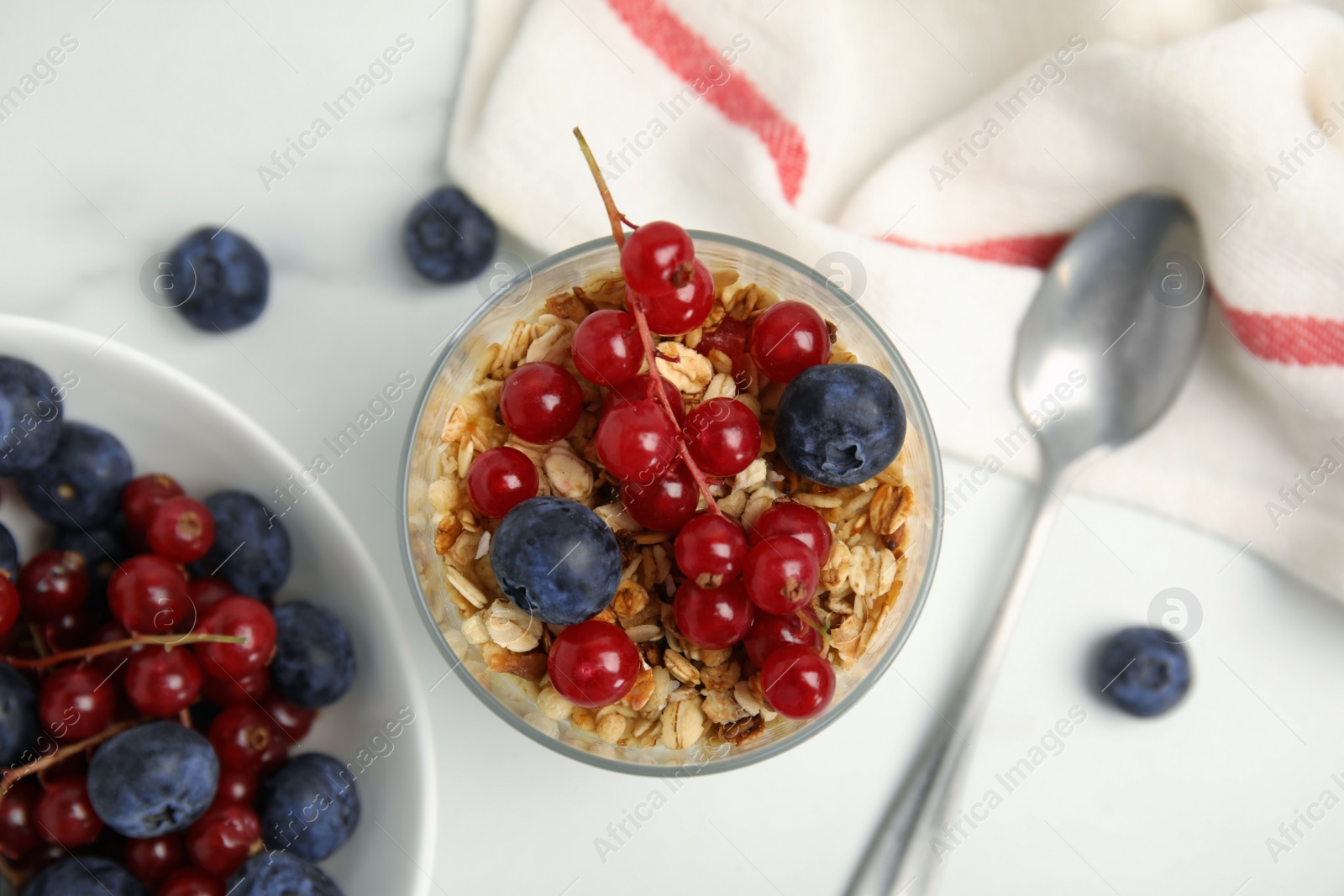 Photo of Delicious yogurt parfait with fresh berries on white table, flat lay
