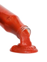 Photo of Pouring tasty ketchup from bottle isolated on white. Tomato sauce