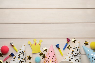 Photo of Flat lay composition with party hats and other festive items on white wooden background. Space for text