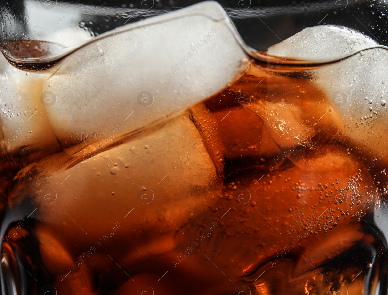 Photo of Glass of tasty refreshing cola with ice cubes, closeup